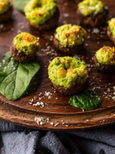spinach and ricotta stuffed mushrooms on wooden platter
