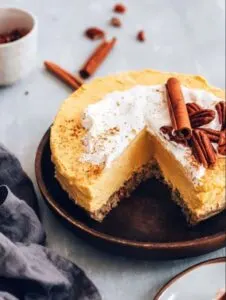 vegan pumpkin cheesecake on stone plate with slice cut out