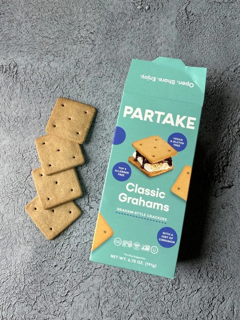 box of partake class grahams top 9 allergen free graham crackers on concrete with four crackers next to the box
