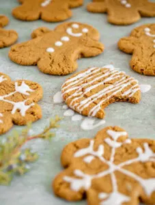 gluten free gingerbread cookies with white icing on parchment