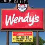 A photo of a Wendy's drive-thru road sign with text overlay that says 'Wendy's Gluten Free Menu'