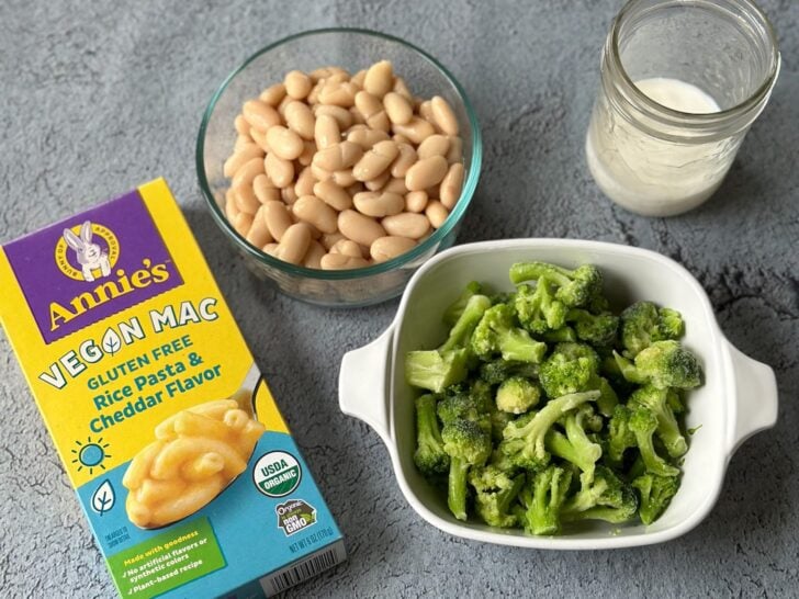 annies' gluten-free mac and cheese box with a casserole dish that has brocolli inside with a jar of milk and bowl of cannellini beans.