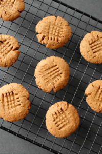 dairy free gluten free peanut butter cookies on cooling rack over dark grey counter