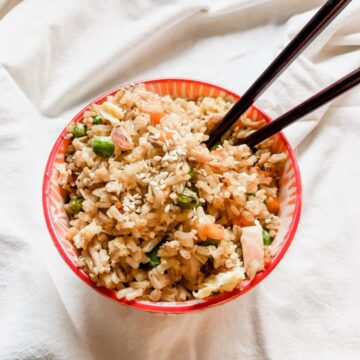 thumbnail image for easy gluten free chicken fried rice in red bowl with chopsticks on white background