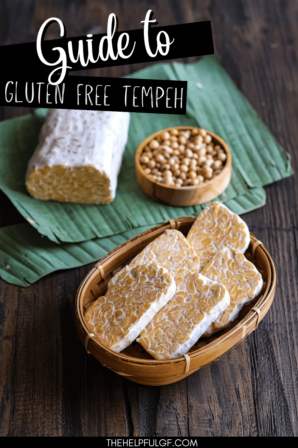 A basked of sliced tempeh, a bowl of soy beans and a loaf of tempeh sitting on a wooden surface with a text overlay that says 'Guide to Gluten Free Tempeh'