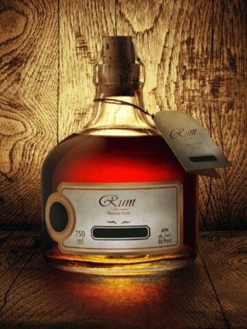 image of bottle of gluten free spiced rum on wooden counter with wooden background