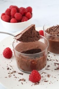 gluten free chocolate mousse scooped out of glass with raspberries