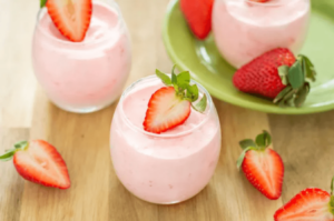 homemade strawberry mousse in glasses topped with cut strawberries