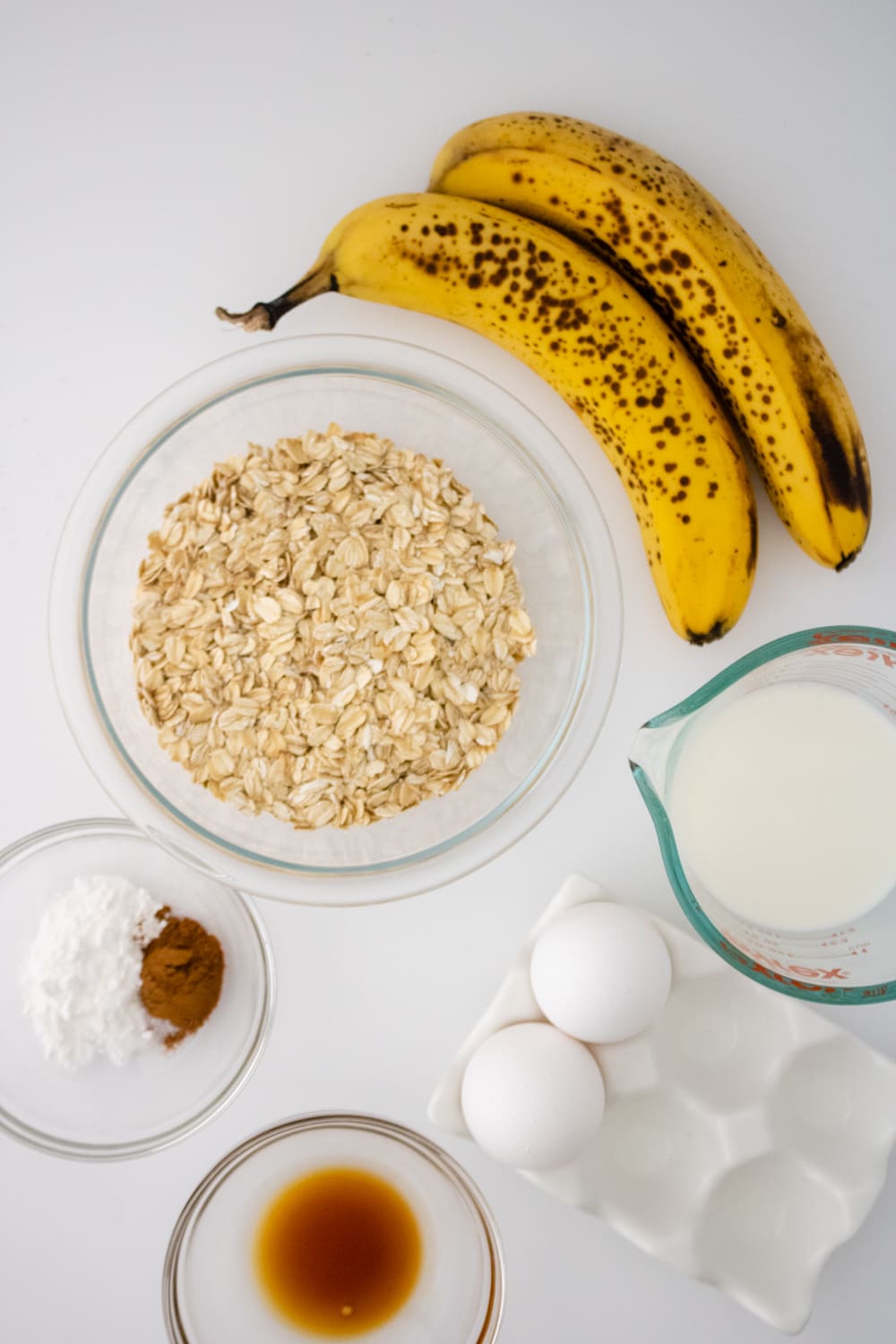 banana oat blender pancakes ingredients featuring gluten free oats, bananas, milk, eggs, baking powder, cinnamon, and vanilla