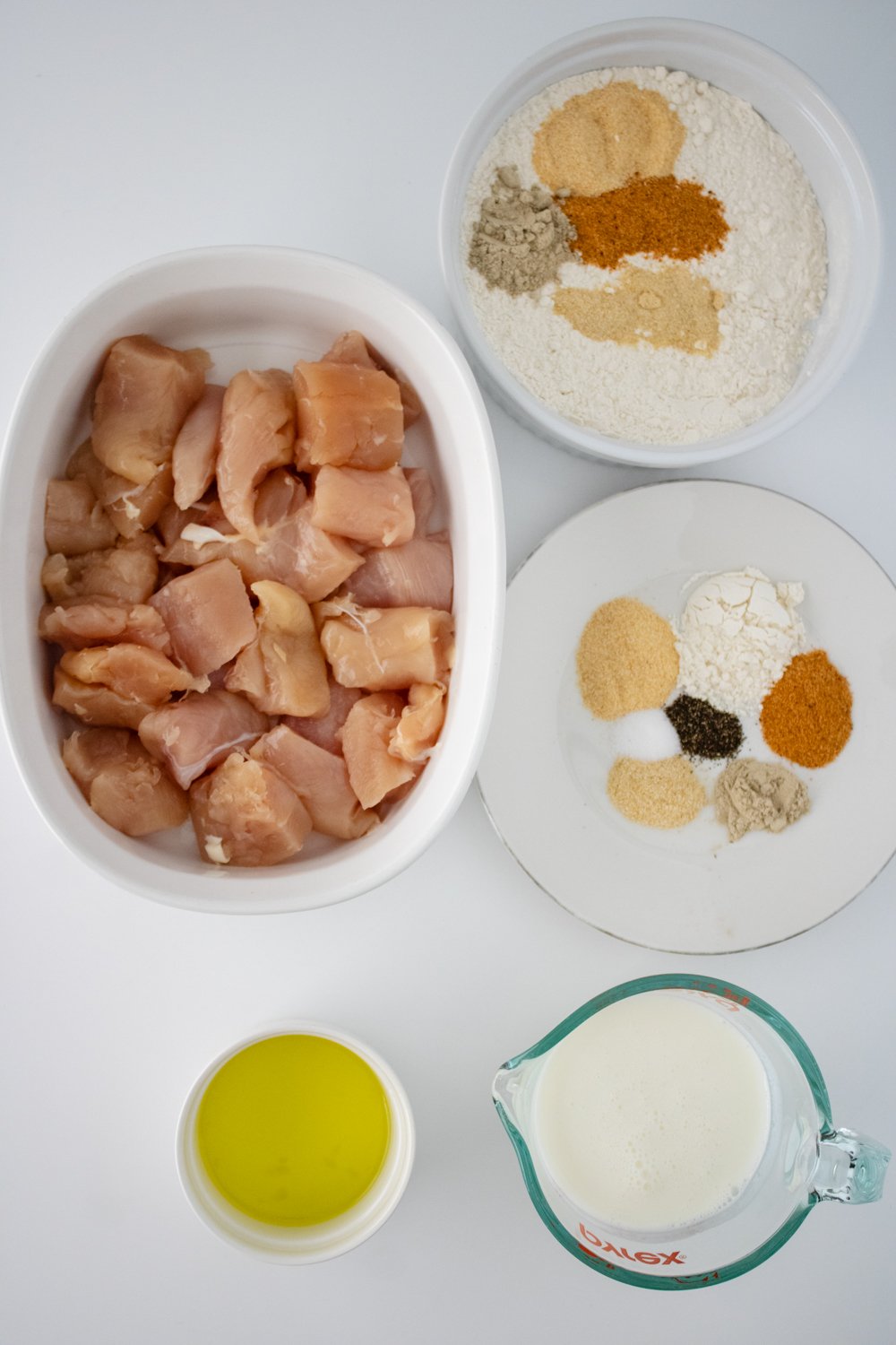 All of the ingredients for gluten free chicken nuggets sitting on a white counter